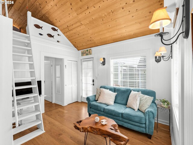 living room featuring vaulted ceiling, wood ceiling, built in shelves, and light wood-type flooring