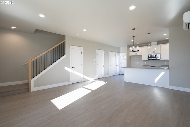 kitchen featuring wood-type flooring, pendant lighting, white cabinets, and an inviting chandelier