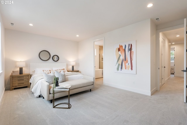 bedroom with light colored carpet and connected bathroom