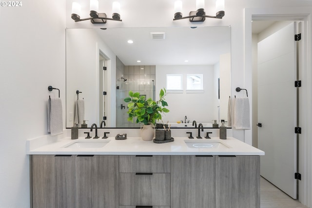 bathroom featuring vanity, a tile shower, and tile patterned flooring