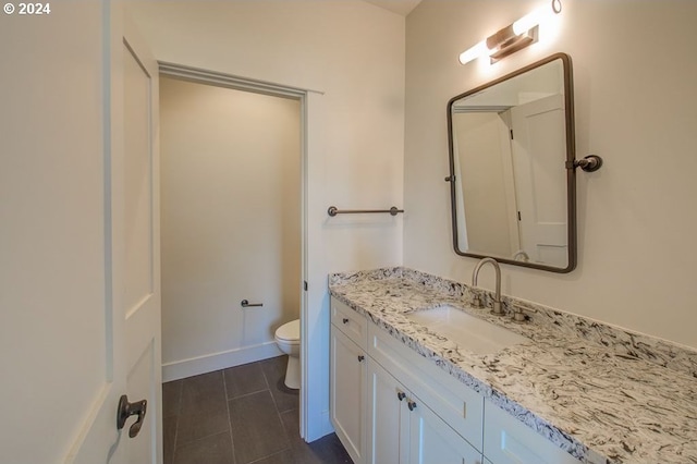 bathroom with vanity, toilet, and baseboards