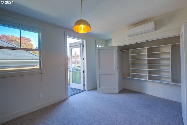 interior space with plenty of natural light, baseboards, a wall mounted air conditioner, and carpet floors