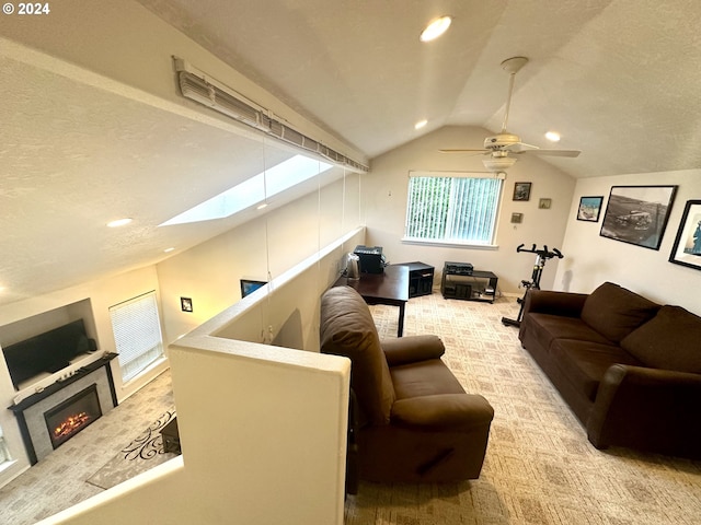 146 28th St, Long Beach, WA 98631 - living room featuring lofted ceiling, carpet, a skylight, a glass covered fireplace, and recessed lighting