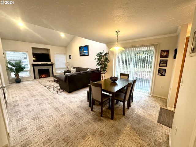 146 28th St, Long Beach, WA 98631 - dining space with light colored carpet, vaulted ceiling, a textured ceiling, baseboards, and a tile fireplace