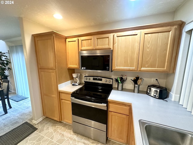 146 28th St, Long Beach, WA 98631 - kitchen with appliances with stainless steel finishes, light countertops, light brown cabinetry, baseboards, and recessed lighting
