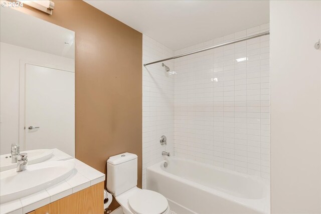 full bathroom featuring vanity, toilet, and tiled shower / bath