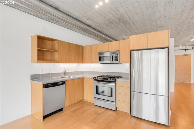 kitchen featuring appliances with stainless steel finishes, light brown cabinets, light hardwood / wood-style floors, and sink