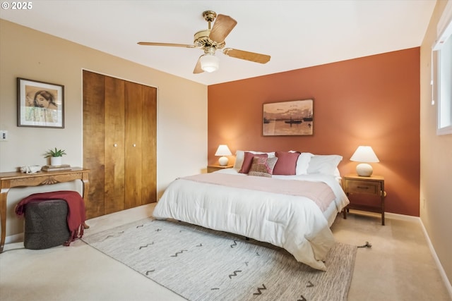 carpeted bedroom with ceiling fan, baseboards, and a closet