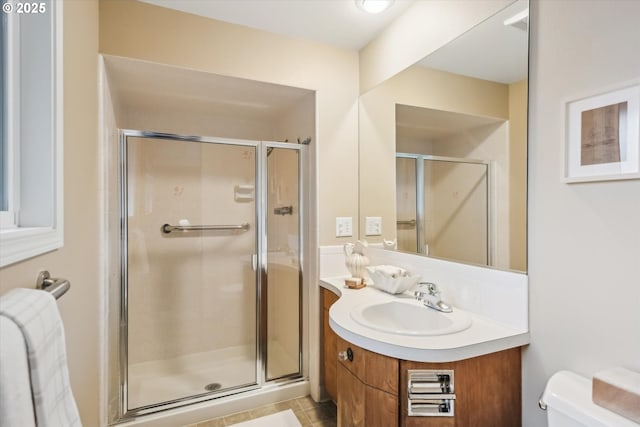 bathroom featuring a shower stall, toilet, and vanity