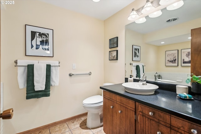 bathroom featuring visible vents, toilet, vanity, baseboards, and tile patterned floors