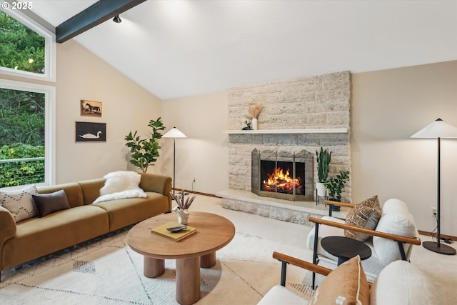 living area featuring vaulted ceiling with beams, a wealth of natural light, a fireplace, and baseboards