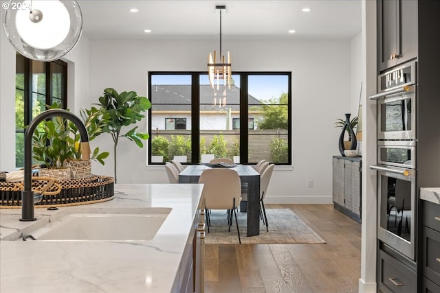 dining room featuring an inviting chandelier, dark hardwood / wood-style flooring, sink, and a wealth of natural light