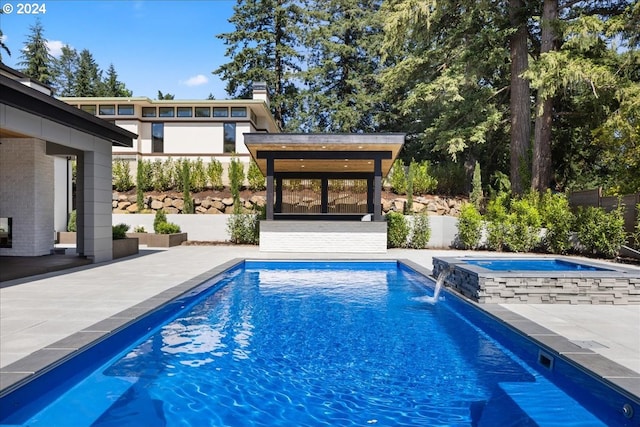 view of swimming pool featuring an in ground hot tub, pool water feature, a gazebo, and a patio area