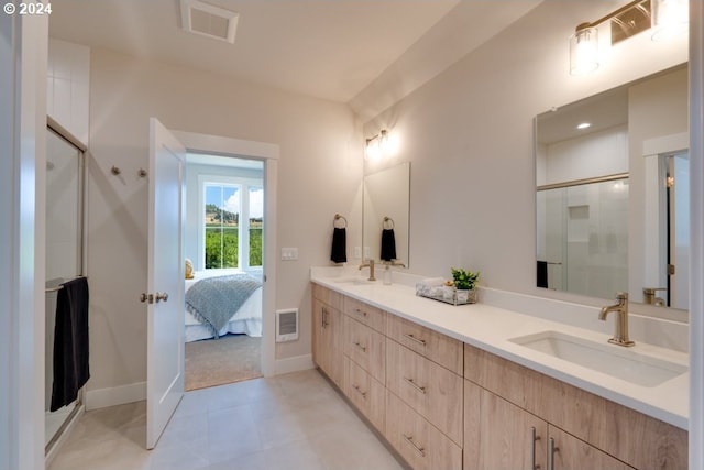 bathroom with an enclosed shower, vanity, and tile patterned floors