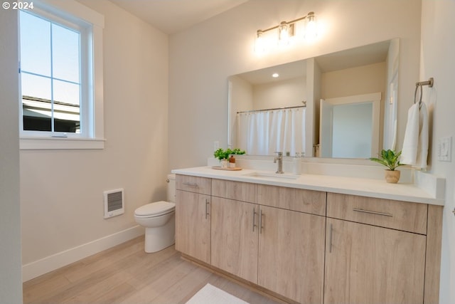 bathroom with vanity, toilet, and wood-type flooring