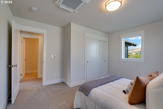 bedroom featuring light carpet and a closet