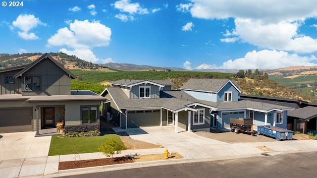 view of front of house with a front lawn, a mountain view, and a garage