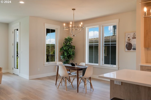 dining room with a wealth of natural light, a notable chandelier, and light hardwood / wood-style flooring