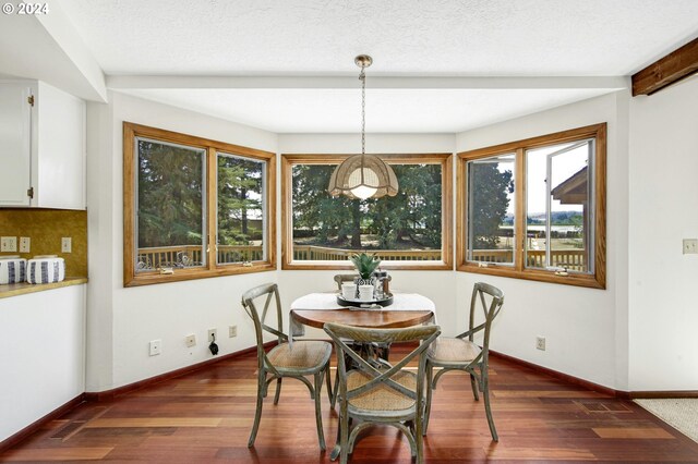 dining room featuring a textured ceiling and dark wood-type flooring