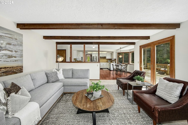 living room with a textured ceiling, beam ceiling, and hardwood / wood-style flooring