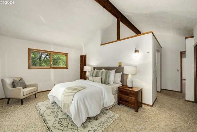 bedroom featuring lofted ceiling with beams, light colored carpet, and a textured ceiling