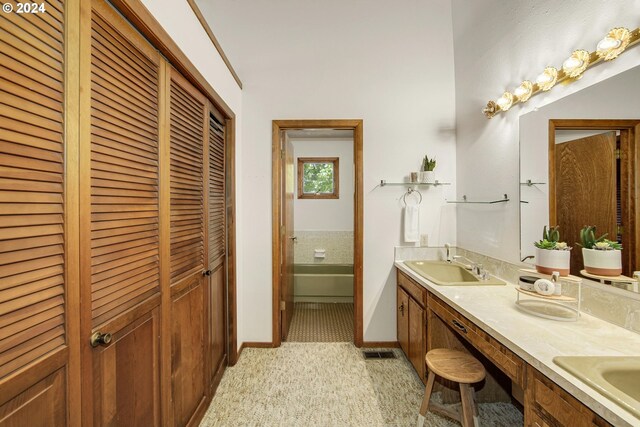 bathroom featuring a tub, tile patterned flooring, and double vanity