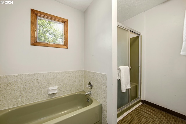 bathroom featuring independent shower and bath and a textured ceiling