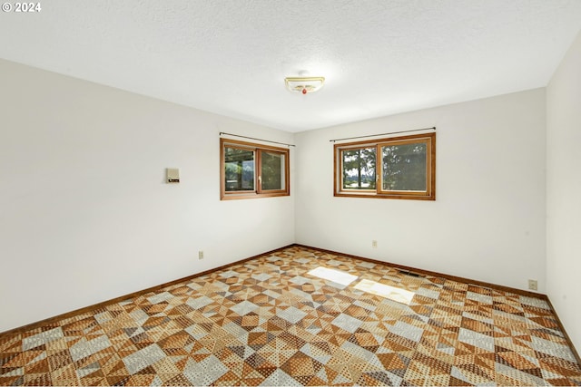 unfurnished room featuring a textured ceiling