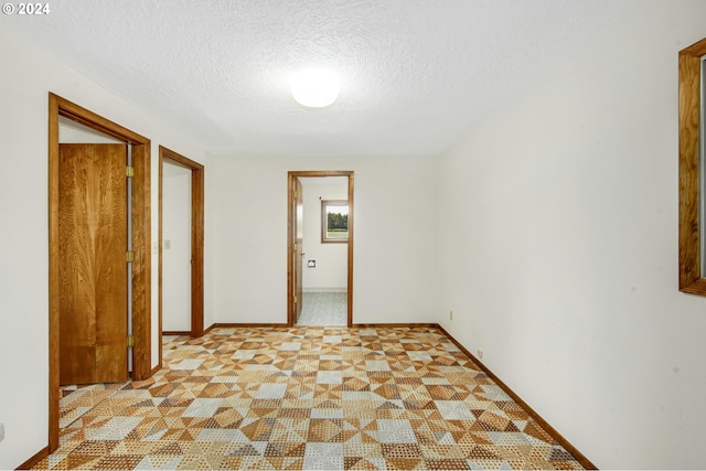 tiled spare room with a textured ceiling