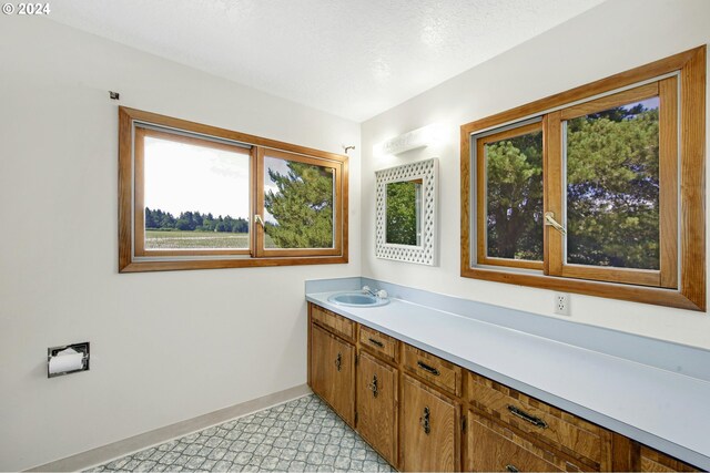 bathroom with tile patterned floors, a textured ceiling, and vanity