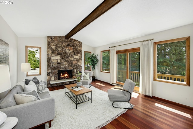 living room featuring hardwood / wood-style flooring, lofted ceiling with beams, and a stone fireplace