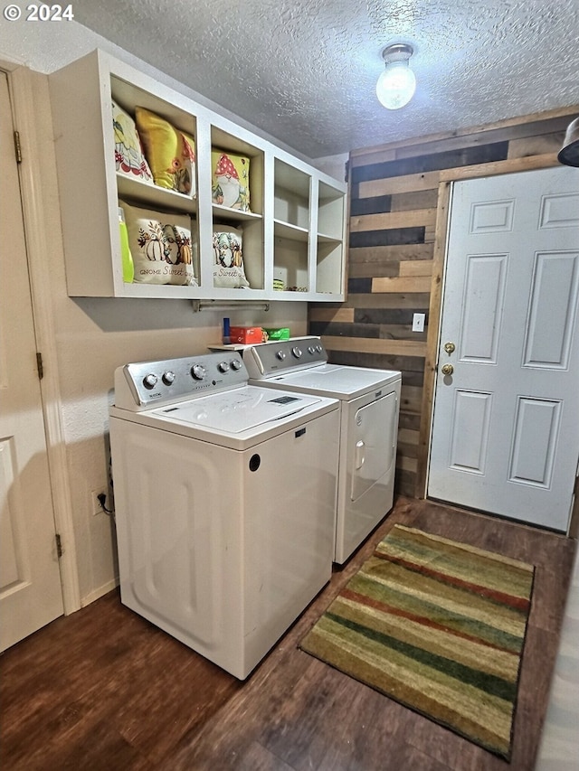 laundry room featuring washing machine and dryer, dark wood-type flooring, and a textured ceiling