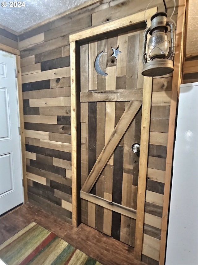 stairway with wooden walls and a textured ceiling