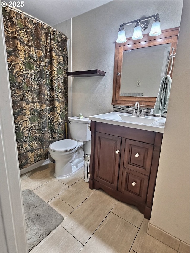 bathroom featuring vanity, tile patterned flooring, toilet, and walk in shower