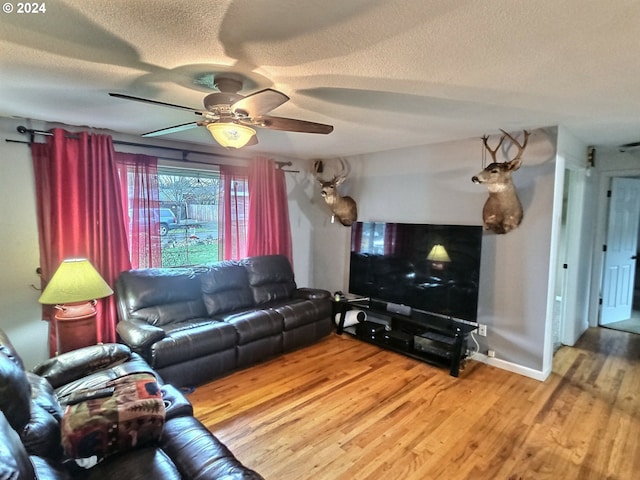 living room with ceiling fan, wood-type flooring, and a textured ceiling