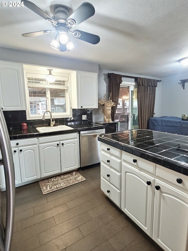 kitchen featuring white cabinetry, sink, decorative backsplash, and dishwasher