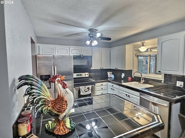 kitchen with stainless steel appliances, sink, decorative backsplash, and white cabinets