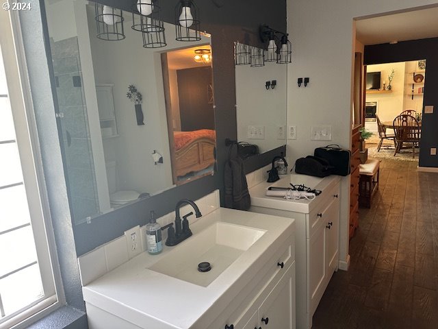 bathroom featuring a notable chandelier, vanity, hardwood / wood-style floors, and toilet