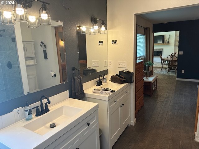 bathroom with double vanity and hardwood / wood-style floors