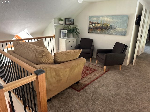 living room with carpet flooring and vaulted ceiling with skylight