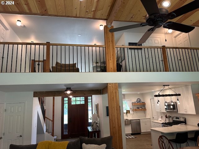 living room featuring ceiling fan and a towering ceiling