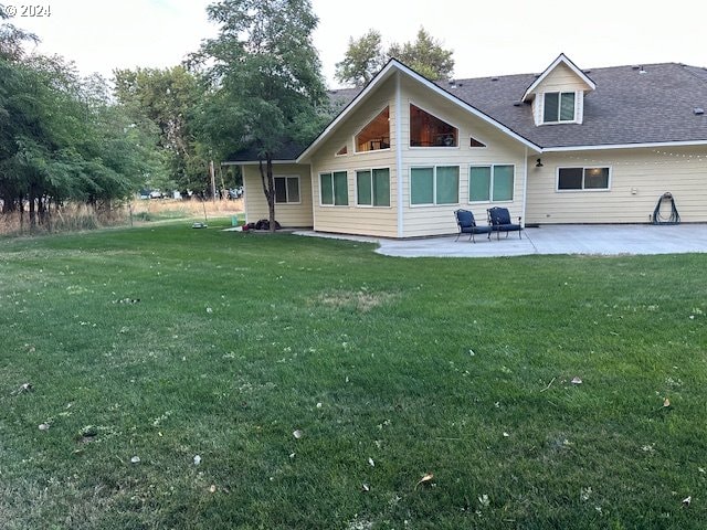 rear view of house with a lawn and a patio