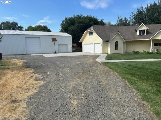 view of front of property featuring an outbuilding, a garage, and a front yard