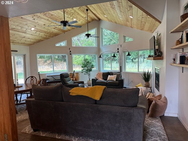 living room with ceiling fan, vaulted ceiling, wood-type flooring, and wooden ceiling