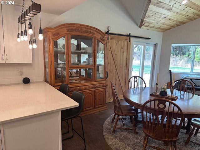 dining room featuring vaulted ceiling and a barn door