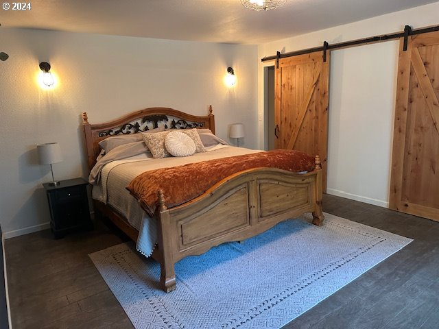 bedroom with hardwood / wood-style floors and a barn door