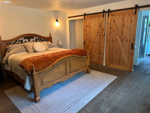 bedroom featuring hardwood / wood-style flooring and a barn door