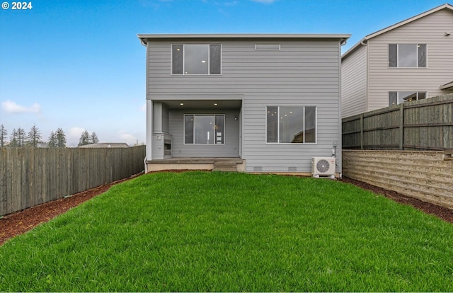 rear view of property with ac unit and a yard