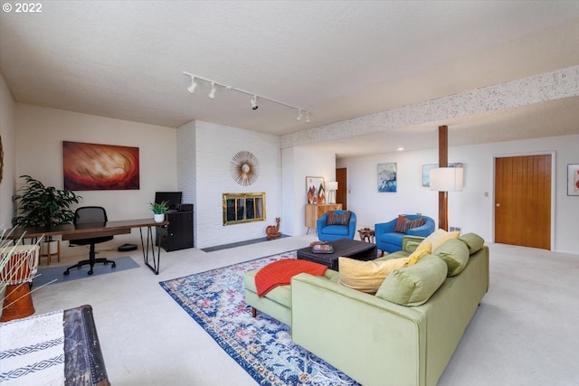 living room with a textured ceiling, rail lighting, and light colored carpet