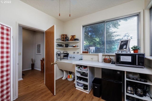 home office with hardwood / wood-style floors and a textured ceiling